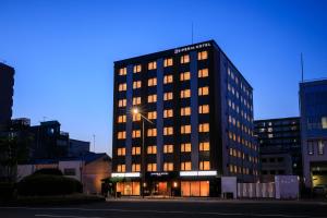 a tall black building with lights on it at S-peria Hotel Kyoto in Kyoto
