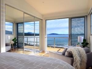 a bedroom with a bed and a view of the ocean at Absolute Waterfront in Gerroa