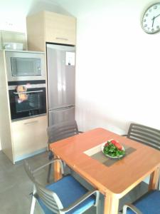 una cocina con una mesa de madera con un tazón de verduras. en Euskal Dreams Apartment, en Bermeo