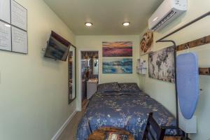 sypialnia z łóżkiem z niebieską narzutą w obiekcie East Downtown Micro-luxe Container Living Pod #10 w mieście Houston