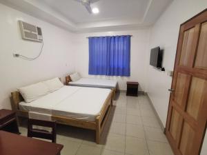 a room with two beds and a window and a door at CafeMare Rooms in Bantayan Island