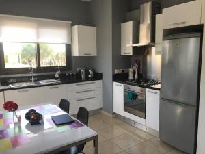 a kitchen with a table and a stainless steel refrigerator at Villa Kallista in Pissouri