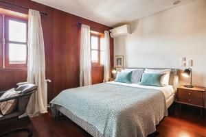 a bedroom with a bed with blue pillows at Charming Bonfim Penthouse in Porto