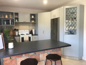 cocina con encimera negra y 2 sillas en The Klein House en Whanganui