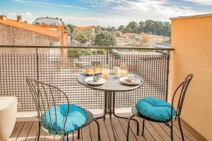 a table and chairs on a balcony with a view at Charming Bonfim Penthouse in Porto +24 photos