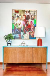 a table with a lamp and a painting on the wall at Charming Bonfim Penthouse in Porto