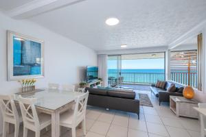 a living room with a table and a couch at On The Beach Resort Bribie Island in Woorim