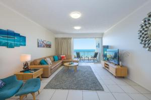 a living room with a couch and a tv at On The Beach Resort Bribie Island in Woorim