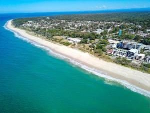 uma vista aérea de uma praia com edifícios e o oceano em On The Beach Resort Bribie Island em Woorim