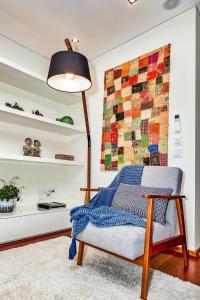a living room with a chair and a lamp at Charming Bonfim Penthouse in Porto