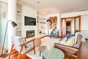 a living room with a couch and a fireplace at Charming Bonfim Penthouse in Porto