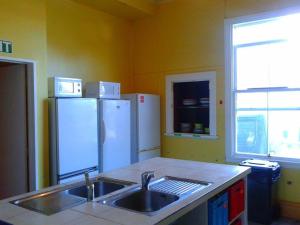 a kitchen with a sink and two refrigerators at Jack's Backpackers in Blenheim