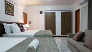 um quarto de hotel com uma cama e um sofá em B & A Suites Inn Hotel - Quarto Luxo Palladium em Anápolis