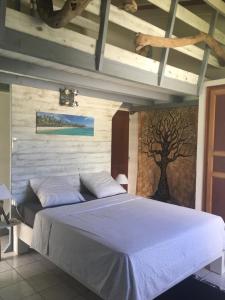 a bedroom with a bed with a tree painted on the wall at Le repaire des Caraïbes in Trois-Rivières