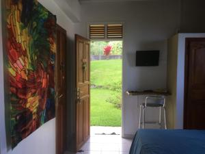 a bedroom with a painting on the wall next to a door at Le repaire des Caraïbes in Trois-Rivières