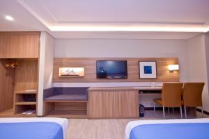 マニラにあるCrown Regency Hotel Makatiの机とテレビがあるホテルの部屋