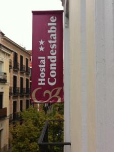 un cartello rosso sul lato di un edificio di Hostal Condestable a Madrid