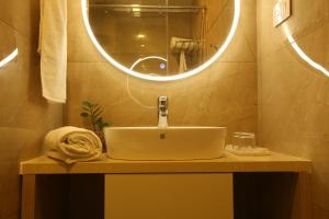 W łazience znajduje się umywalka i lustro. w obiekcie Mintotel Wayanad w mieście Sultan Bathery