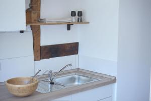 a kitchen sink with a wooden bowl next to it at Laubach Ferienwohnung - Fam.Lorenz in Laubach