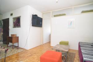 a living room with a tv and a table and chairs at Apartment NL in Sarajevo