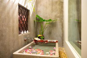 a bath tub filled with water in a bathroom at Sabara Angkor Resort & Spa in Siem Reap