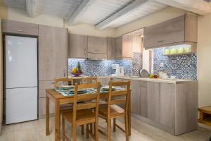 a kitchen with a table and chairs and a refrigerator at Diogenis House in Moírai