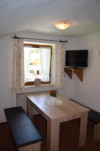 Mały pokój z drewnianym stołem i oknem w obiekcie Landhaus Spielmannsau w mieście Oberstdorf