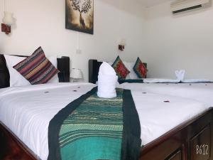 two beds sitting next to each other in a room at Jasmine Vangvieng Hotel in Vang Vieng