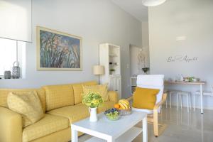 a living room with a yellow couch and a table at SgS Luxury Apartments in Xylokastron