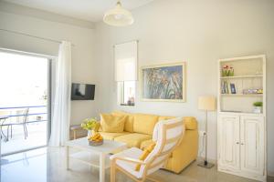 a living room with a yellow couch and a table at SgS Luxury Apartments in Xylokastron