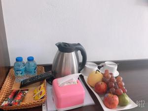 a table with a coffee pot and fruit on it at Jasmine Vangvieng Hotel in Vang Vieng