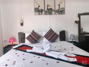 a bedroom with a bed with towels on it at Jasmine Vangvieng Hotel in Vang Vieng