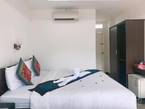 a bedroom with a white bed in a room at Jasmine Vangvieng Hotel in Vang Vieng