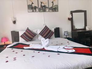a bedroom with a bed with towels on it at Jasmine Vangvieng Hotel in Vang Vieng