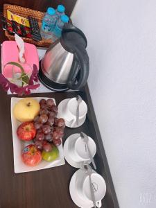a table with a plate of fruit and a tea kettle at Jasmine Vangvieng Hotel in Vang Vieng