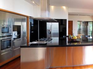 a kitchen with stainless steel appliances and a black counter top at Villa Minh in Kamala Beach