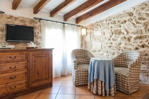 a living room with two chairs and a tv at Hotel Can Simo in Alcudia