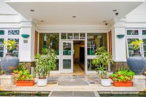 una puerta delantera de una casa con macetas en Super OYO Collection O 1452 Hotel Utari en Bandung
