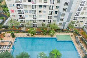 an overhead view of a swimming pool in front of a building at Brand New Cozy Studio at Scientia Apartment By Travelio in Tangerang