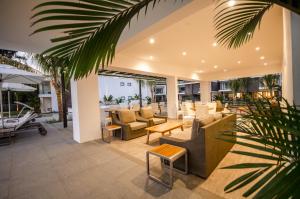 a living room with couches and a table at Latitude - with private plunge pool in Rivière Noire