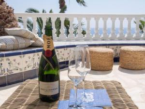 Una botella de vino y dos copas en una mesa. en Frontline villa, five star deluxe, en El Campello