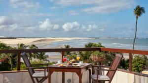 a table and chairs on a balcony with a view of the beach at Rox Hotel in Jericoacoara