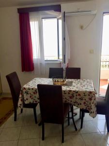Apartments Marina في سفيتي ستيفان: غرفة طعام مع طاولة وكراسي مع طاولة وطاولة وكراسي