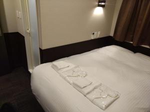 a bed with two white towels on top of it at Hotel Excellence Kyoto Station Nishi in Kyoto