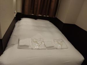 a bed with white sheets and towels on it at Hotel Excellence Kyoto Station Nishi in Kyoto