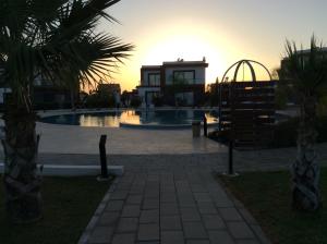 puesta de sol sobre una piscina en un complejo en Salamis Park en Famagusta