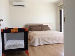 a white bedroom with a bed and a small crib at Salamis Park in Famagusta