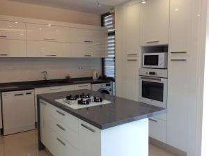 a kitchen with white cabinets and a stove top oven at Salamis Park in Famagusta