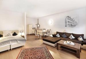 a living room with a bed and a couch and a table at Hotel Freischütz Apartments in Landshut