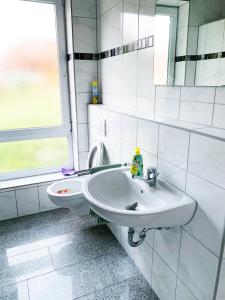a white bathroom with a sink and a window at My-Skypalace Neckarsulm in Neckarsulm
